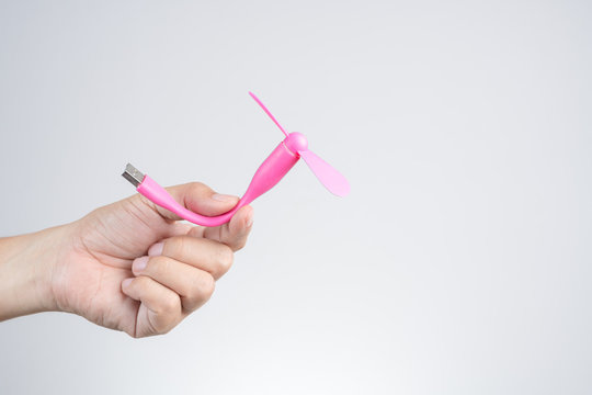 Hand holding pink mobile usb fan, use power from computer or powerbank