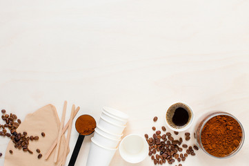 Background with Ingredients for coffee and paper cups on the white table