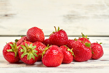 Close up group of fresh juicy strawberries. Heap of freshly harvested strawberries on light background.