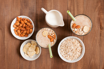 Ingredients and two portion of smoothies on the wooden table