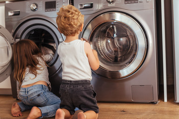 Kids playing with washing machine at home