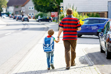 Young father taking child, kid boy to school on his first day