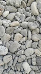 Sea round glossy stones background, top view.