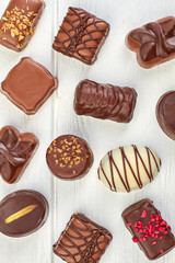 Assortment of chocolate candies on white background. Sweet background with assorted candies.