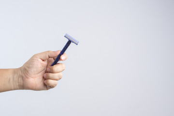 Hand holding disposable and cheap shaving razor