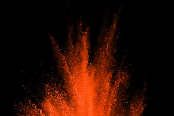 OrangeRed powder explosion isolated on black background. Explosion of colored clouds or  dust...