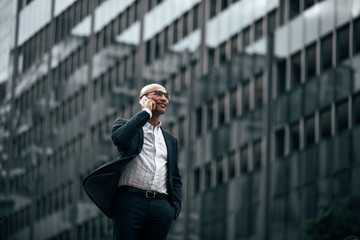 Businessman standing outdoors talking over mobile phone