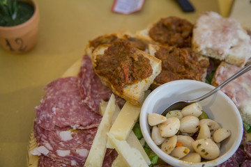 image with detail of typical Italian food products, salami and bruschetta.with wild boar sauce and lard