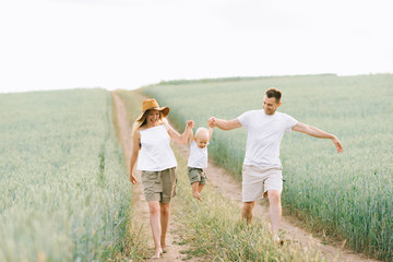 A young family have a fun with their little baby in the field