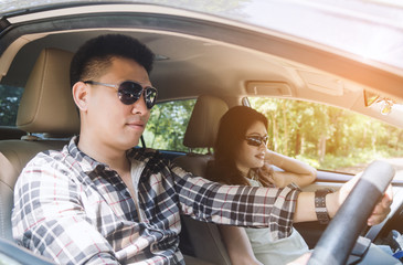 Young couple on a road trip in their car. Filtered image.