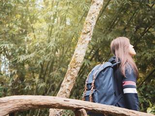 photographer and adventure in nature concept from beauty long hair asian woman in warm suit and backpack travel  relax and feel good in tropical forest