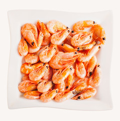 Shrimps on a square white dish on white background