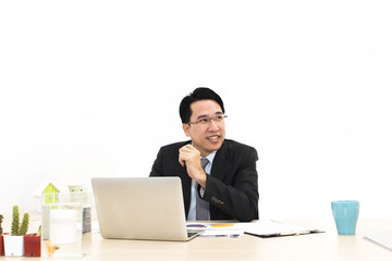 Young businessman working with laptop and office Supplies.He looking smiling.Copy space.