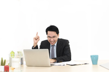 Young businessman working with laptop and office Supplies.He looking smiling.Copy space.