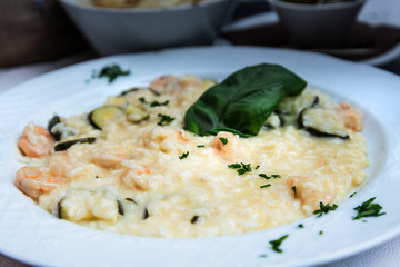 Tasty risotto with Shrimp, fresh herbs vegetables on a white plate