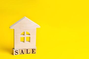 wooden house on a yellow background with the inscription "sale". sale of property, home, real estate. affordable housing. place for text. copyspace