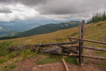 Fototapeta na wymiar Old wooden fence in the Carpathians near the hills