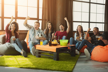 Happy football fans watching soccer on tv