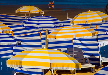 Blue-white and yellow-white sun umbrellas on beach in Belgium 
