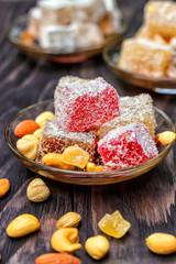 Traditional oriental sweets and traditional Turkish tea on a dark wooden background. Turkish desert-Rahat locum.