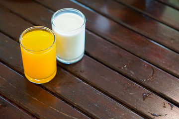 Beautiful desert milk and orange juice for refresh in the morning on the wooden table.