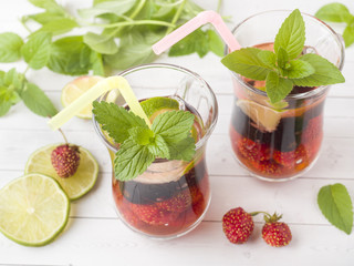 Cocktail with black currant, strawberry, mint and lime. Cooling summer drink.
