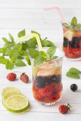 Cocktail with black currant, strawberry, mint and lime. Cooling summer drink.