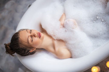 Relaxed young woman laying in bathtub. enjoyment concept