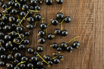 Fresh Raw Black Currant berry on brown wood