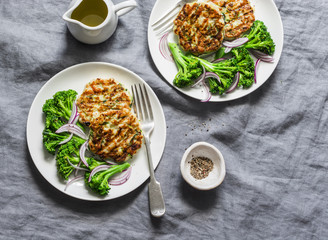 Zucchini chicken burgers and poached broccoli on a gray background, top view. Healthy balanced food...