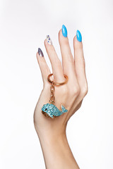 Beautiful summer blue manicure with crystals on female hand. Close-up. Picture taken in the studio