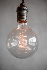Edison retro lamp on gray plaster background. Concept loft hipster mood