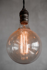 Edison retro lamp on gray plaster background. Concept loft hipster mood
