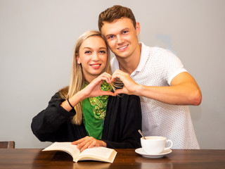 couple in love concept.boyfriend and girlfriend feeling happy smiley face with cup of cappuccino coffee and book on table