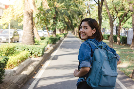 Summer lifestyle portrait of young tourist asian woman walking on the street, carry backpack. Travel tourist woman with backpack outdoors during holidays enjoying the view. Women lifestyle concept.