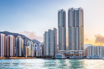 Fototapeta na wymiar Hong Kong Island, Eastern Part. Residential area with business and government buildings. Sunset sky on background. Contrast between modern skyscrapers and Asia nature. View from Victoria Harbour. 