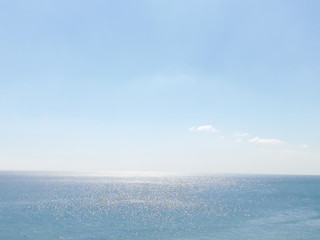 Naklejka na ściany i meble shiny black sea under a blue sky background