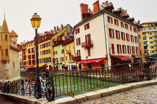 Annecy, France - March, 2018: Cityscape in the raining city Annecy with canal, bicycle and colorful buildings.