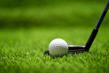 Golf ball on green grass ready to be struck at golf club