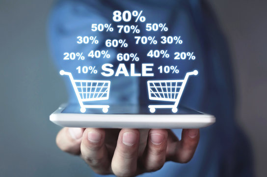 Businessman holding a tablet with a shopping basket with discount . Online shopping
