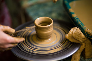 Sculpts in clay pot closeup. Modeling clay close-up. Caucasian man making vessel daytime of white clay in fast moving circle. Art, creativity. Ukraine, cultural traditions. Hobbies