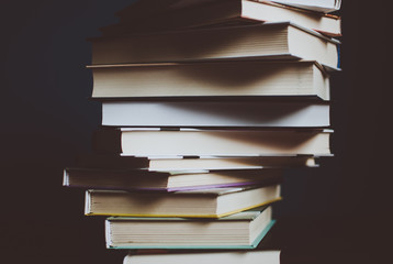 Tower of colorful books on the table. Closeup of pages. Abstract concept of knowledge, education,...