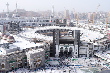 MECCA, SAUDI ARABIA - MAY 02 2018: View on central Mecca square near Masjid Al Haram mosque from balcony at restaurant on top of Clock Tower or Abraj Al Bait. Crowd of people walking, day light