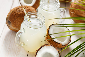 Refreshing coconut water in jars. Close-up.