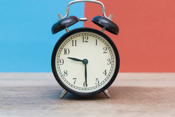 black bell clock on blue and red background