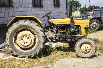 An old tractor produced in the 70s of the 20th century. Photo of the side of the agricultural machine. The necessary equipment for a dairy farm.