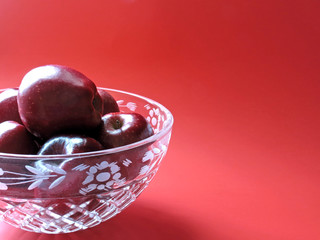 Crystal fruit bowl filled with red Delicious apples, with space for text.