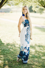 portrait of a young woman with long hair in a dress breathing fresh air on a sunny summer day