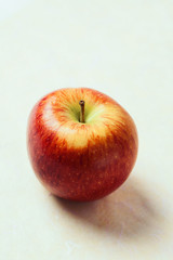 Single fresh apple on slightly colored background
