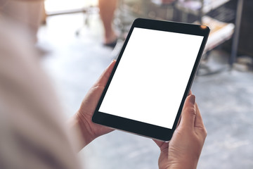 Mockup image of woman's hands holding black tablet pc with white blank desktop screen in cafe